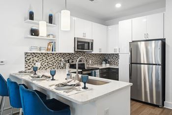 a kitchen with a island and a stainless steel refrigerator at Link Apartments® Mint Street, Charlotte, NC, 28203